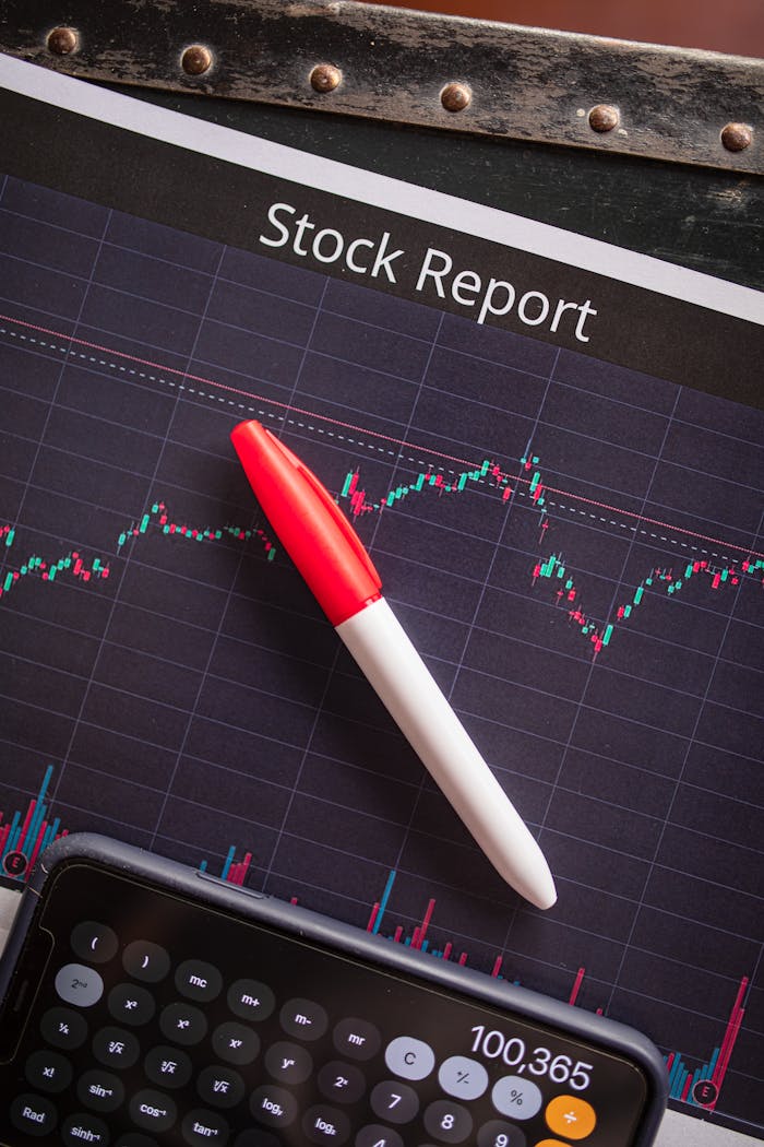 Close-up of a stock report with a pen and calculator for financial analysis.